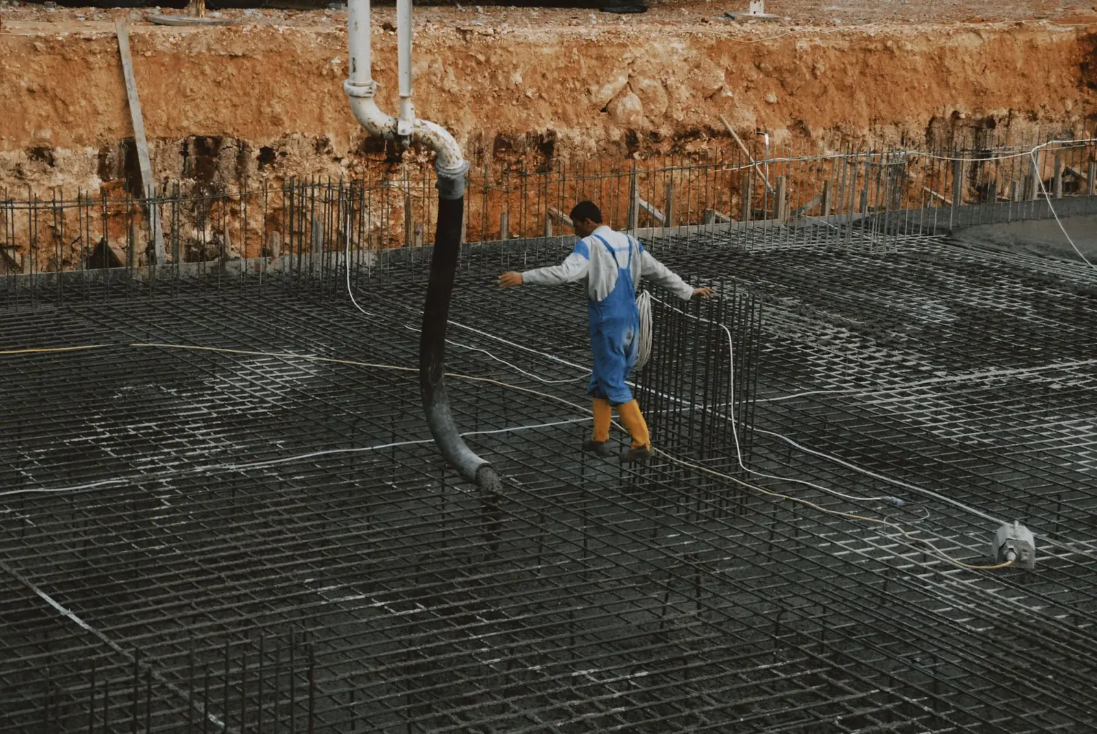 Steel reinforcement grid tied inside a pool excavation before concrete